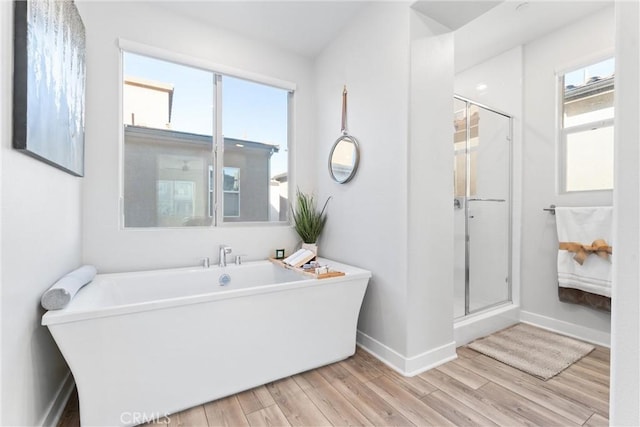 bathroom with hardwood / wood-style flooring and separate shower and tub