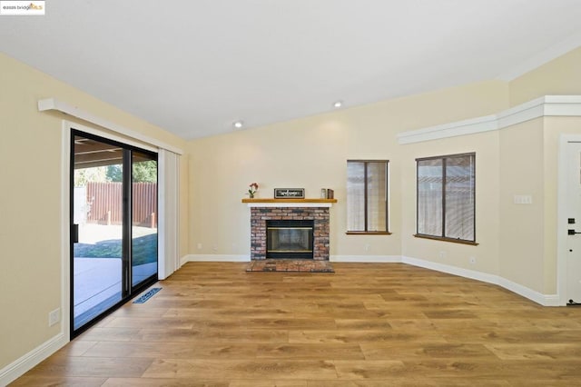 unfurnished living room with a fireplace and light hardwood / wood-style floors