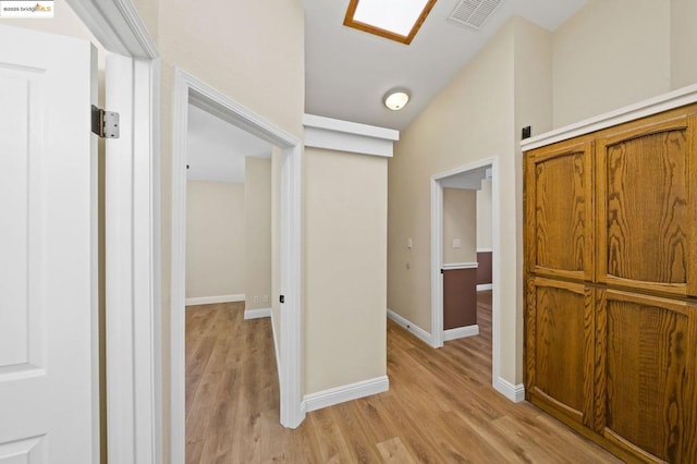 hall featuring lofted ceiling and light wood-type flooring