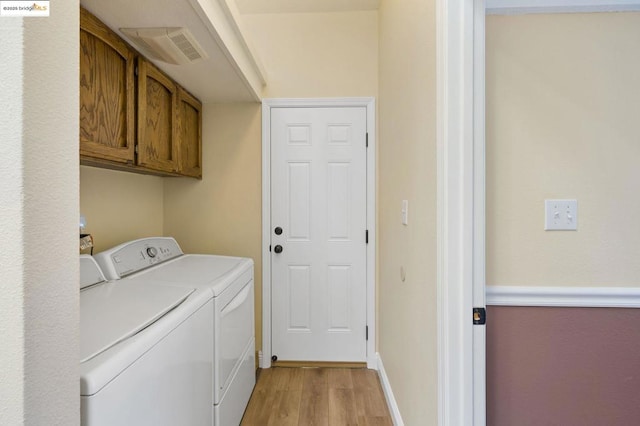 washroom featuring cabinets, washer and dryer, and light hardwood / wood-style floors