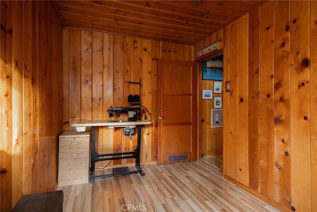 interior space featuring wooden walls, light hardwood / wood-style floors, and wooden ceiling