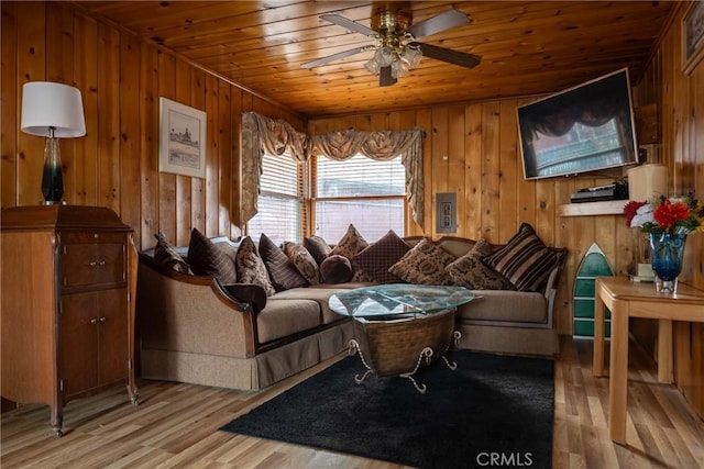 living room with wooden walls, light hardwood / wood-style floors, and wooden ceiling