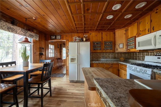 kitchen with wood walls, light hardwood / wood-style flooring, hanging light fixtures, wooden ceiling, and white appliances