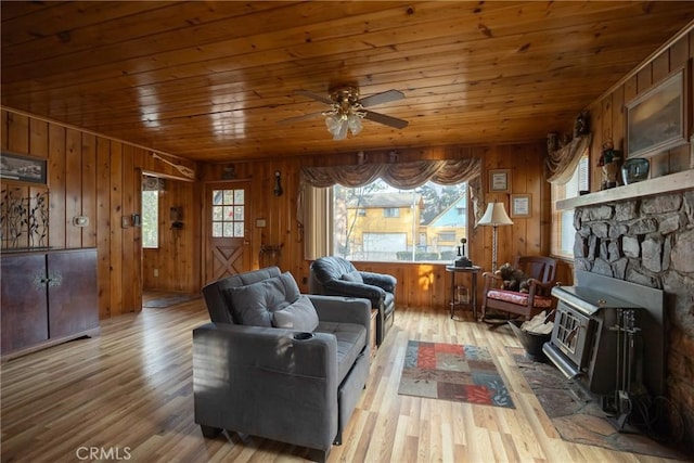 living room with hardwood / wood-style floors, wood ceiling, wooden walls, and ceiling fan