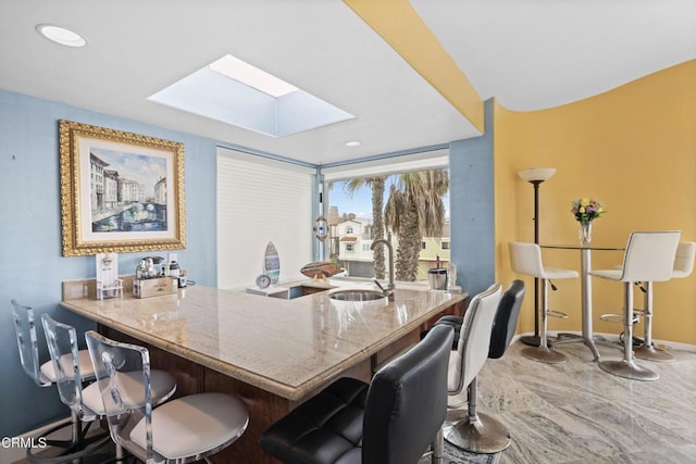 dining space featuring sink and a skylight