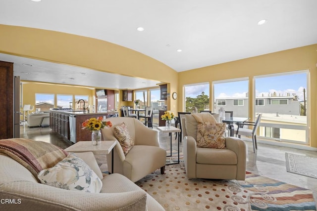 living room featuring lofted ceiling and sink