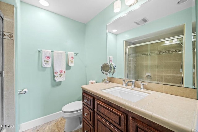 bathroom featuring vanity, an enclosed shower, and toilet