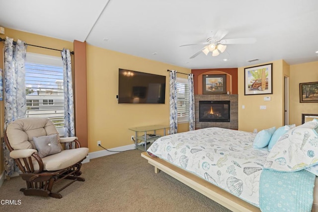 bedroom featuring ceiling fan, carpet, and a fireplace