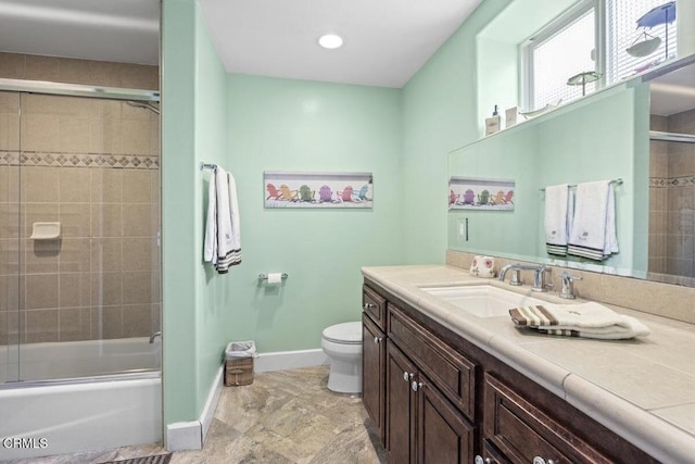 full bathroom with bath / shower combo with glass door, vanity, and toilet