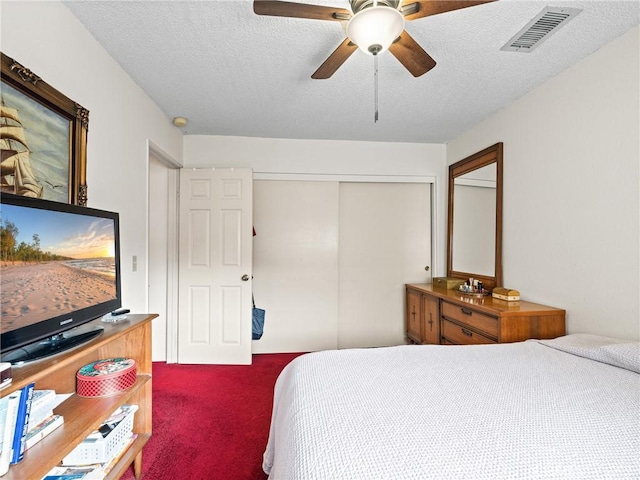 bedroom with ceiling fan, carpet floors, a textured ceiling, and a closet