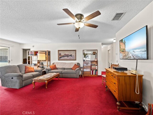 carpeted living room with ceiling fan and a textured ceiling