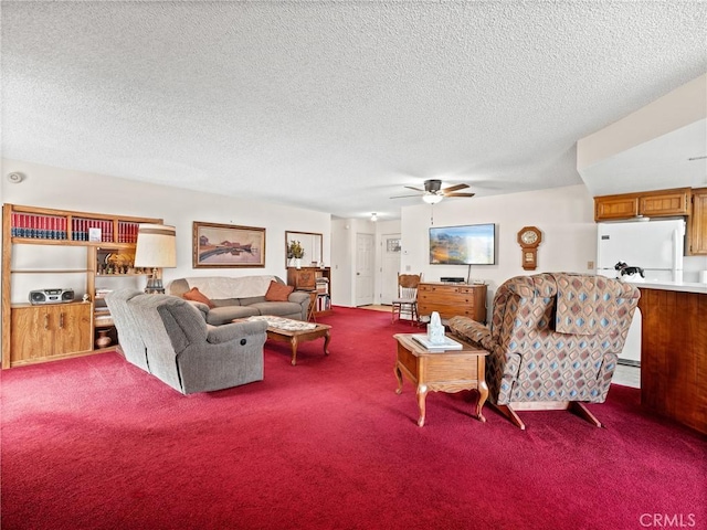 living room with ceiling fan, carpet flooring, and a textured ceiling