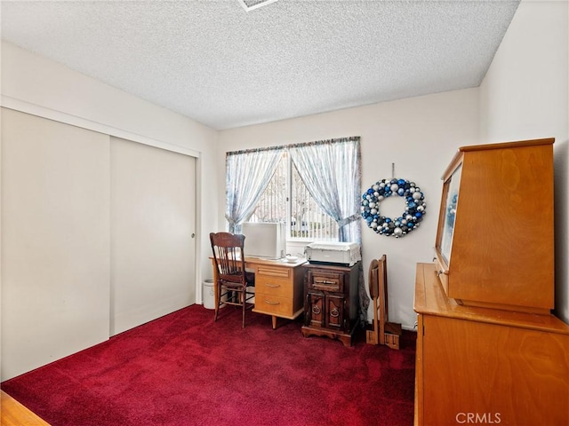 carpeted office space with a textured ceiling