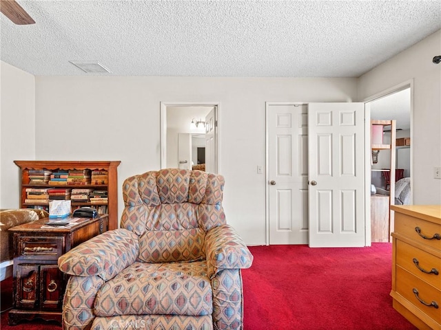 living area with dark carpet and a textured ceiling