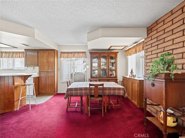 dining area with dark colored carpet and a textured ceiling