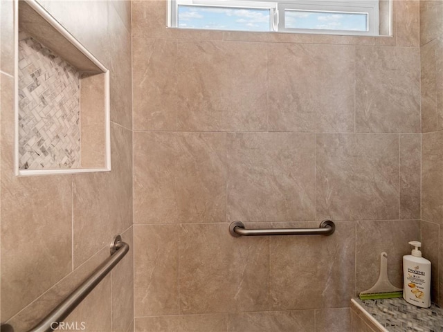 bathroom featuring tiled shower and a wealth of natural light