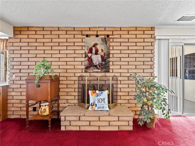 interior space featuring carpet floors, a textured ceiling, and a fireplace