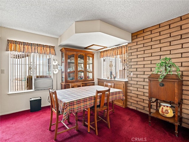 dining area featuring a wealth of natural light, a textured ceiling, and dark carpet