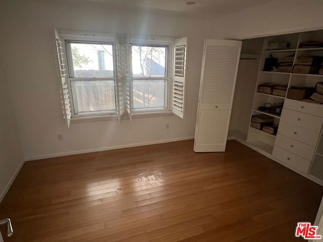 unfurnished bedroom with hardwood / wood-style floors and a closet