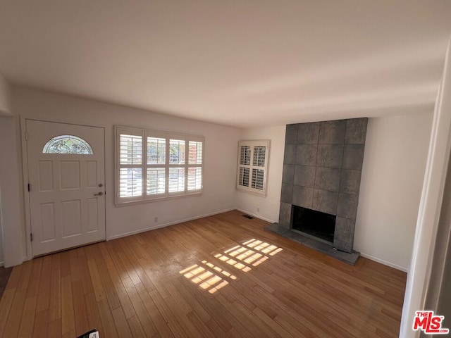 entrance foyer featuring a tile fireplace and light hardwood / wood-style floors