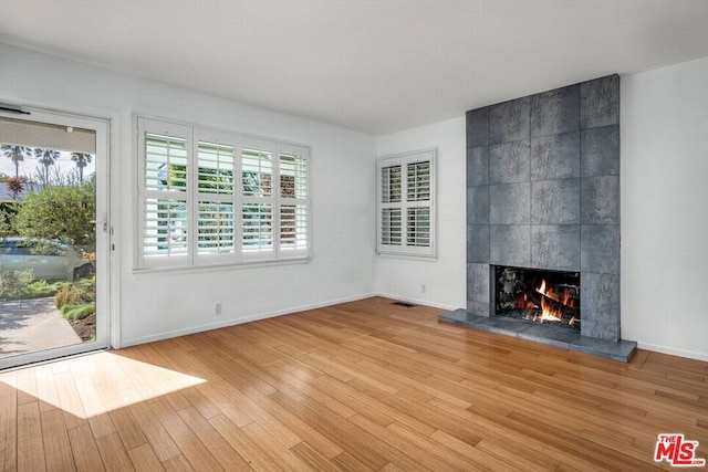 unfurnished living room with a fireplace and light hardwood / wood-style floors