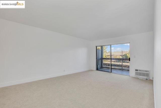 carpeted empty room featuring a wall mounted AC