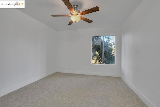 carpeted spare room with ceiling fan