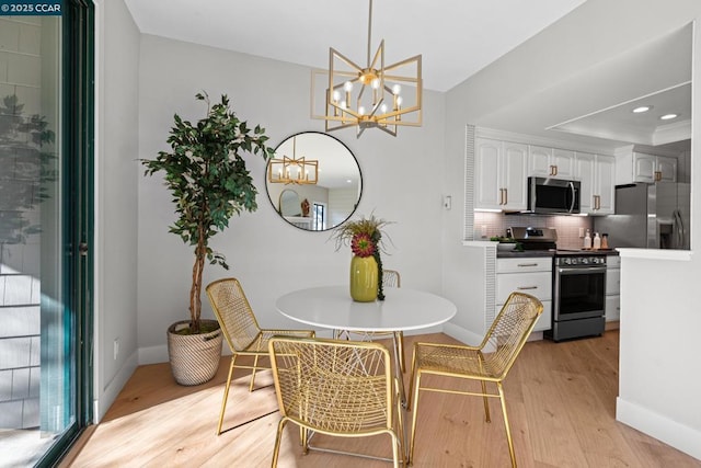 dining space with a notable chandelier, light wood-type flooring, and a tray ceiling