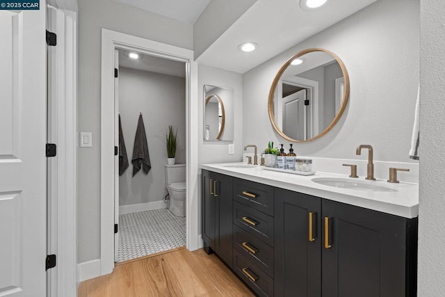 bathroom with hardwood / wood-style flooring, vanity, and toilet