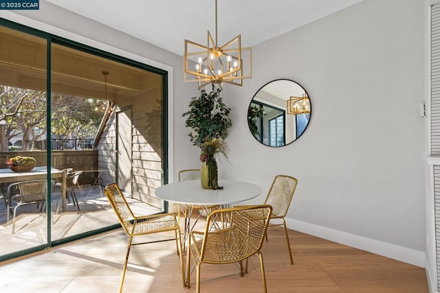 dining area with light hardwood / wood-style flooring and a notable chandelier