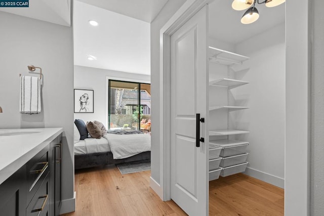 bedroom featuring sink and light hardwood / wood-style flooring