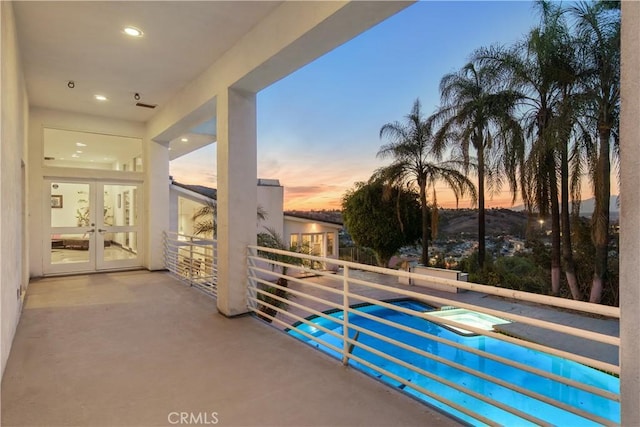 balcony at dusk with french doors and a patio