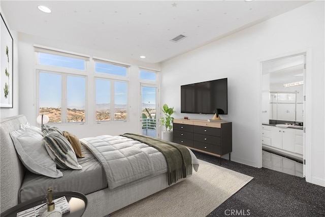 bedroom featuring multiple windows, ensuite bathroom, and carpet floors