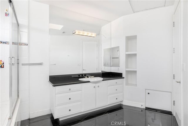 bathroom featuring vanity, bath / shower combo with glass door, and tile patterned flooring