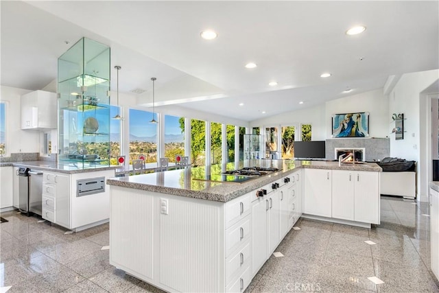 kitchen featuring pendant lighting, stainless steel gas cooktop, white cabinets, vaulted ceiling, and kitchen peninsula