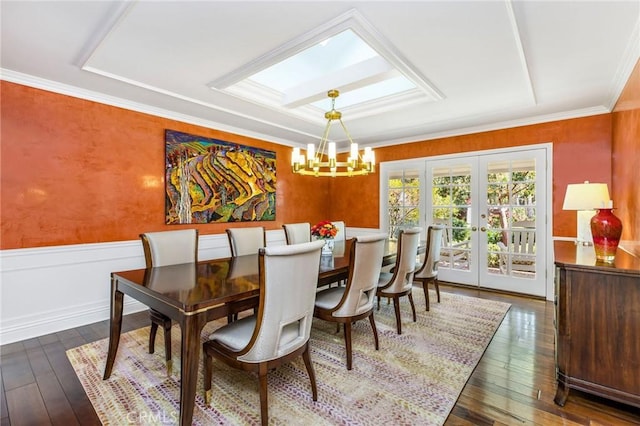 dining room with crown molding, dark wood-type flooring, an inviting chandelier, and french doors