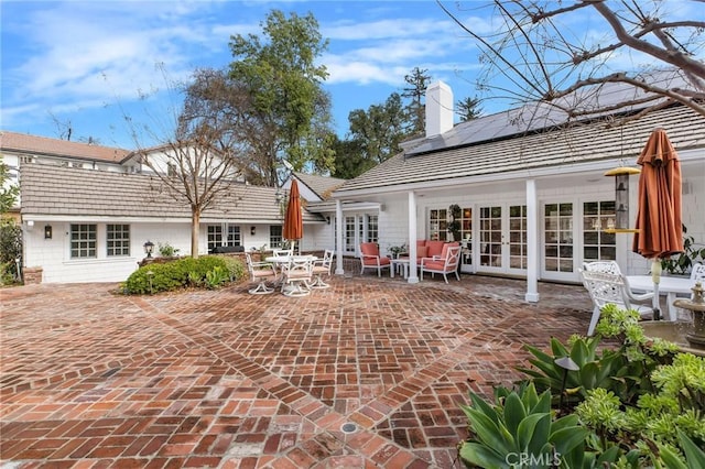 back of house featuring a patio area, french doors, and solar panels