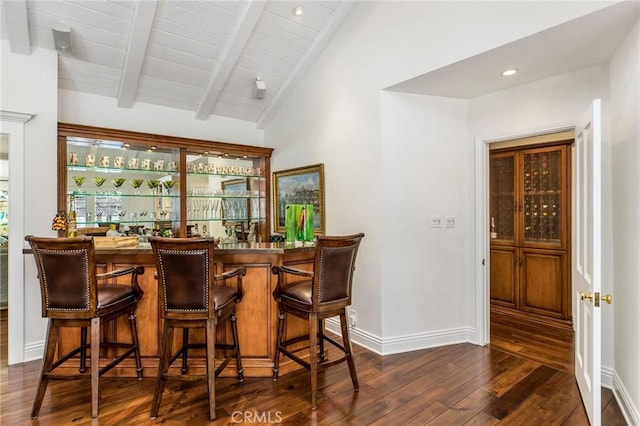 bar with dark hardwood / wood-style floors and vaulted ceiling with beams