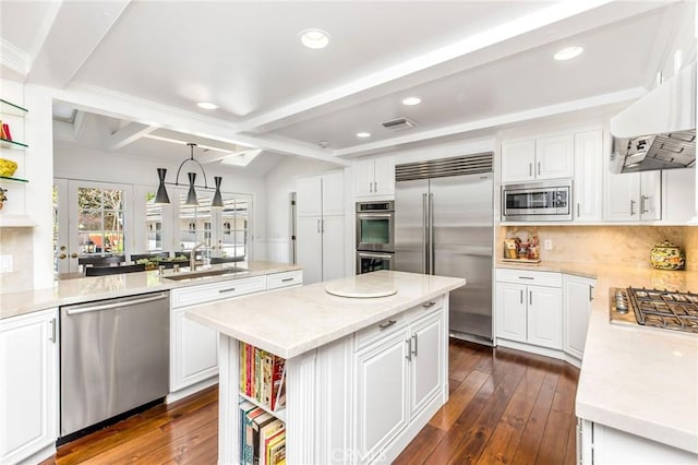 kitchen featuring a kitchen island, pendant lighting, white cabinetry, sink, and built in appliances