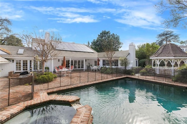 view of pool with french doors, a patio area, and a gazebo