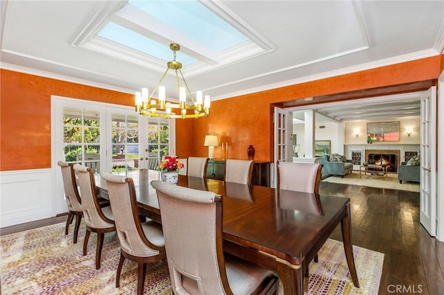 dining room featuring french doors, an inviting chandelier, ornamental molding, dark hardwood / wood-style flooring, and a raised ceiling