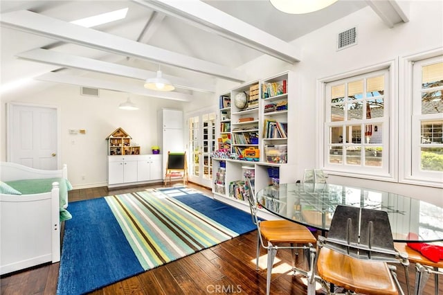 playroom with a wealth of natural light, lofted ceiling with beams, and dark hardwood / wood-style floors