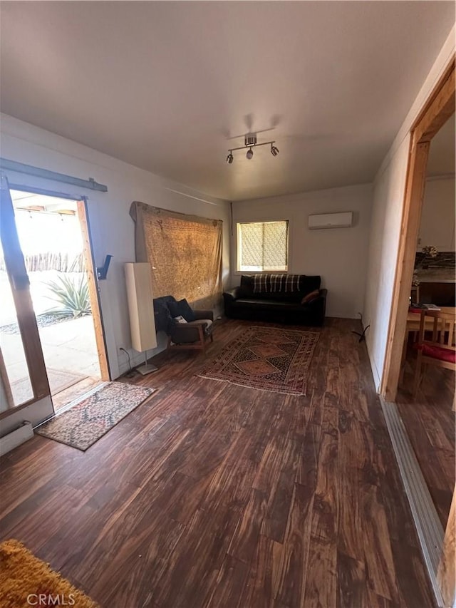 unfurnished living room with an AC wall unit and wood finished floors