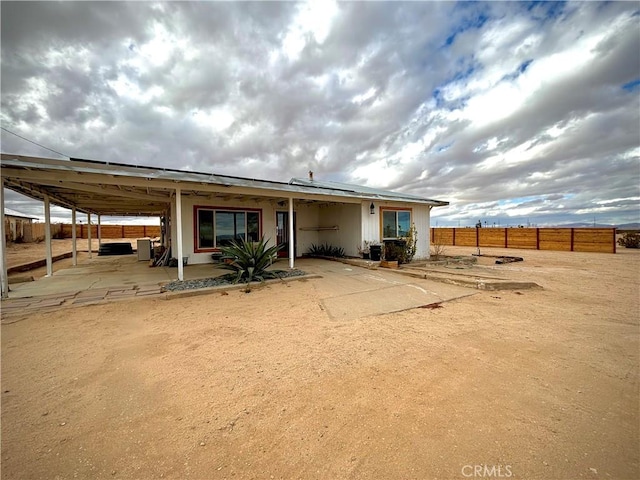 back of house featuring a patio area, fence, and solar panels