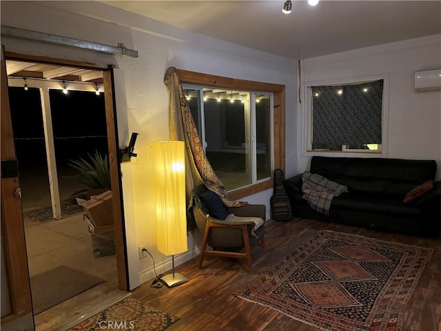 living area featuring wood finished floors and a wall mounted AC