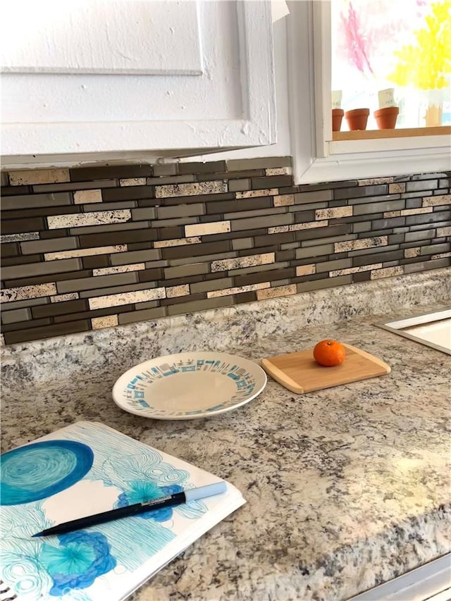 details featuring tasteful backsplash and light stone counters