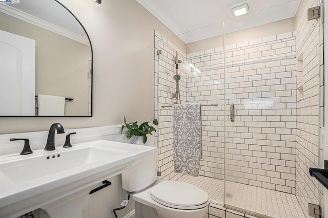 bathroom with crown molding, a shower with door, sink, and toilet