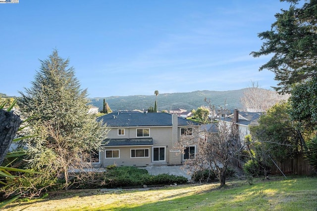 back of house featuring a yard and a mountain view