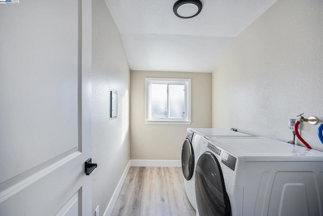 washroom with independent washer and dryer and light hardwood / wood-style floors