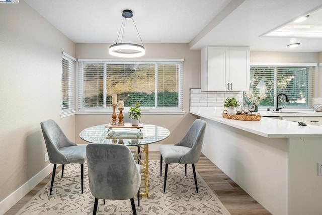 dining space with a healthy amount of sunlight, light hardwood / wood-style floors, and sink